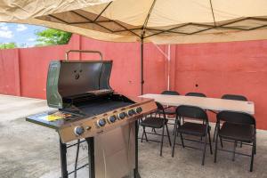 una parrilla en una tienda con mesa y sillas en Oceanview • Mins to the Beach • Private BR Balcony, en Moule à Chique