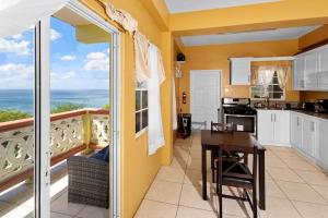 Una cocina con mesa y vista al mar. en Oceanview • Mins to the Beach • Private BR Balcony, en Moule à Chique