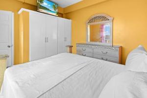 1 dormitorio con cama blanca, tocador y espejo en Oceanview • Mins to the Beach • Private BR Balcony, en Moule à Chique