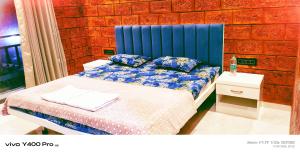 a bed with a blue headboard in a room at Sai Holliday's home in Alibaug