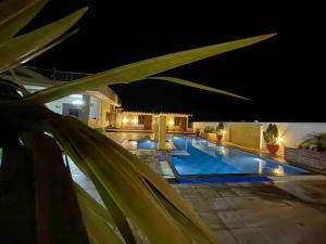 a view of a swimming pool at night at The Starlight Farmstay- Poolside Tent Stay in Jaipur in Jāmb