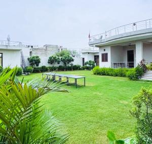 a group of picnic tables in the yard of a building at The Starlight Farmstay- Poolside Tent Stay in Jaipur in Jāmb