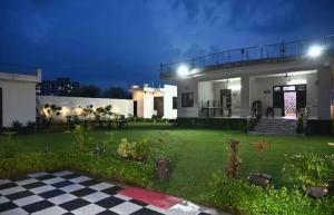a house with a checkered floor in a yard at The Starlight Farmstay- Poolside Tent Stay in Jaipur in Jāmb