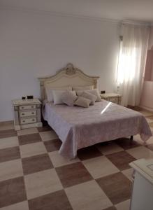 a bedroom with a large bed and a checkered floor at Costa Dorada Villa - Pool BBQ Beach 5min in Calafell +19 photos