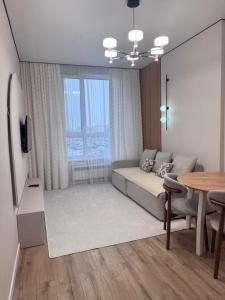 アスタナにあるЛюкс апартамент возле ЭКСПО и Аэропорта!のベッドとテーブルのあるリビングルーム +22枚の写真