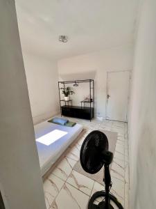 a small room with a bed and a fan at Residência Ruiz Conforto moderno e elegante em São Paulo in Sao Paulo