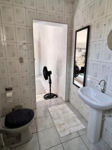 a bathroom with a sink and a toilet and a mirror at Residência Ruiz Conforto moderno e elegante em São Paulo in Sao Paulo