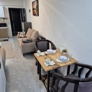 a living room with a table and a couch at Golden Mango Heights - Urban Family Suite - One Bedroom Apartment - Restaurant, Workspace, City Views, Fast WiFi, Sauna, Fitness Facilities, Secure Parking And Kids Play Area in Nairobi