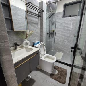 a bathroom with a toilet and a sink and a shower at Golden Mango Heights - Urban Family Suite - One Bedroom Apartment - Restaurant, Workspace, City Views, Fast WiFi, Sauna, Fitness Facilities, Secure Parking And Kids Play Area in Nairobi