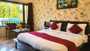 une chambre avec un lit avec une fenêtre et une table dans l'établissement Corbett Nature Walk - Forest View Swimming Pool, à Rāmnagar