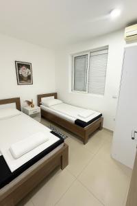ein Schlafzimmer mit zwei Betten und einem Fenster in der Unterkunft Guest house, Small beach in Ulcinj + 7 Fotos