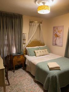 a bedroom with a bed with a green blanket at Mill Creek Mansion in Youngstown