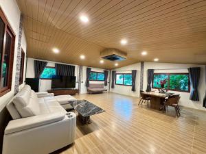 a living room with a white couch and a table at Klongdao Sunset Villa in Ko Lanta