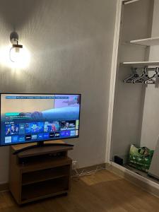 a flat screen tv sitting on a stand in a room at Appartement Lumineux, à 5 minutes de Paris in Asnières-sur-Seine