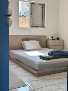 a bed sitting in a room with a window at Residência Ruiz Conforto moderno e elegante em São Paulo in Sao Paulo
