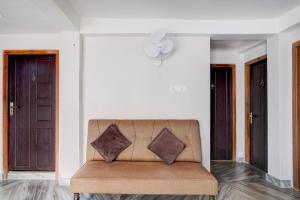 a couch with two pillows sitting in a room at Super Collection O Police Bazar Shillong Formerly Pillars House in Shillong