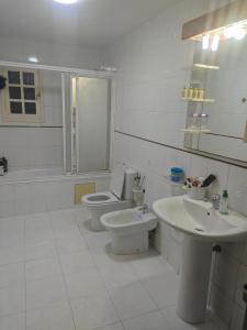 Un baño blanco con inodoro y lavabo. en Chambre paisible et romantique, en Tánger