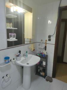 a bathroom with a white sink and a mirror at Chambre Cosy Climatisé, Romantique et indépendante chez l'habitant in Tangier