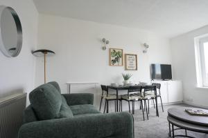 a living room with a couch and a table with chairs at Hyslop Hideaway in Airdrie