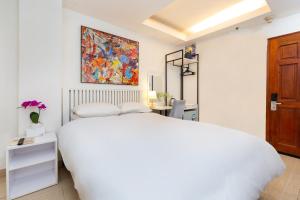 a bedroom with a white bed and a painting on the wall at Boutique Passion Hotel in Ho Chi Minh City +23 photos