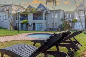 a bench in front of a house with a pool at The Bridge, Apartment 67 in St Lucia