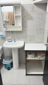 a white bathroom with a sink and a mirror at Habitación 2 en Villa Mariaclaudia in Macas