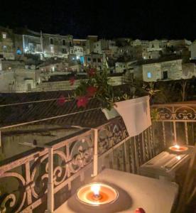 een kaars op een tafel op een balkon 's nachts bij Radici - La finestra sui Sassi in Matera