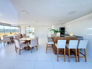 een eetkamer met tafels en witte stoelen bij Apartamento com Área de Lazer na Cobertura in Cururupe