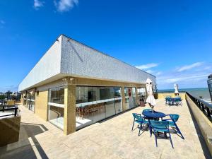 een gebouw met een tafel en stoelen op een patio bij Apartamento com Área de Lazer na Cobertura in Cururupe