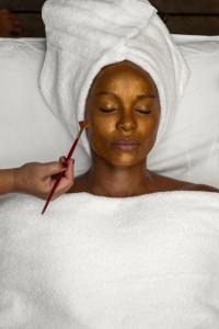 a woman laying in bed with a mask on her face at Vila Almesca in Caraíva