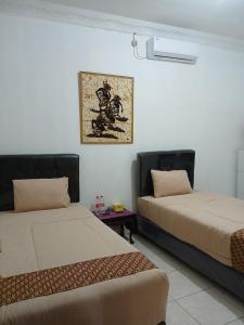 Ένα ή περισσότερα κρεβάτια σε δωμάτιο στο Ndalem Surya Malioboro