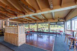 une salle à manger avec tables, chaises et fenêtres dans l'établissement Anchor Lodge, à Fort Bragg