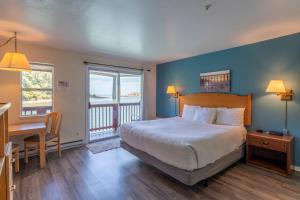 une chambre avec un lit, une table et un bureau dans l'établissement Anchor Lodge, à Fort Bragg