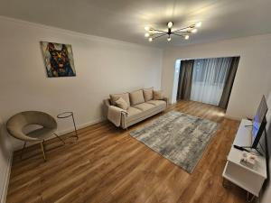 a living room with a couch and a table at White Central Apartment in Bistriţa