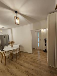 a room with a table and chairs and a ceiling at White Central Apartment in Bistriţa
