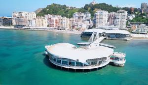 a large boat in the water next to a city at Beachfront Boutique Apartments in Durrës
