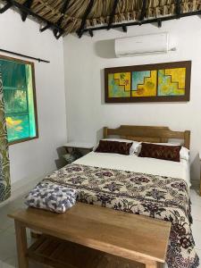 a bedroom with a bed and a wooden table at Zéfiro Hostal in San Bernardo del Viento