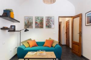 Una sala de estar con un sofá azul y una mesa. en Il Cantuccio di Vittorio - Apartment with private garden in the Heart of Volterra, en Volterra