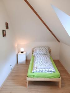 a bedroom with a green bed in a attic at Ubytování nad kostelem in Prague +4 photos