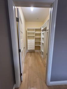 a hallway with a closet with white shelves at Private room with shared bathroom in house - Mini Mansion in Burbank