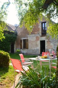 une table et des chaises devant un bâtiment dans l'établissement Les maisons des Frangines, à Oinville-Saint-Liphard 29 autres photos