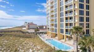 ナバーにあるMermaid Manorのスイミングプールとビーチのあるアパートメントビル