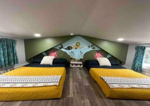 une chambre avec deux lits aux couvertures jaunes et un mur dans l'établissement Waterfall Cottage, Hot Tub, Game Room, Fire Pit, à Mentone