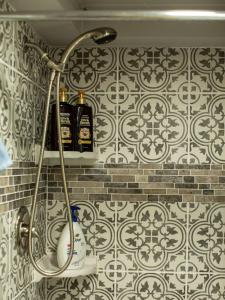 une douche avec deux bouteilles d'alcool sur un mur dans l'établissement Waterfall Cottage, Hot Tub, Game Room, Fire Pit, à Mentone