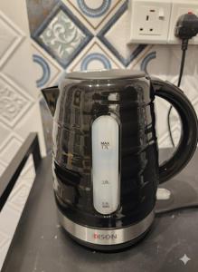 a black coffee pot sitting on top of a counter at شقق النبلاء in Al Madinah