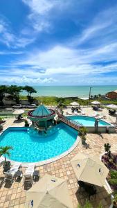 a large swimming pool with chairs and umbrellas at Hotel Costa do Atlantico in Natal