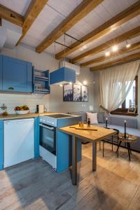 Una cocina con gabinetes azules y una mesa de madera. en Samis Pelion LuxuryLiving, en Portaria