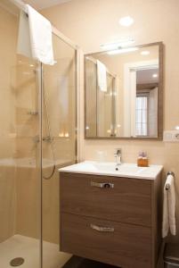a bathroom with a sink and a shower with a mirror at Linares Rooms Santiago in Santiago de Compostela