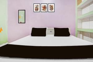 a large bed in a room with three pictures on the wall at SPOT ON Pradhan Hotel in Bhīta