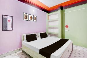 a bedroom with a bed in a room with colorful walls at SPOT ON Pradhan Hotel in Bhīta +21 photos
